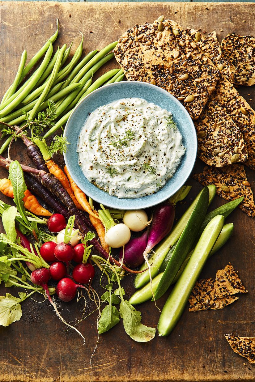 dill dip with fresh vegetables and crackers on the side for dipping