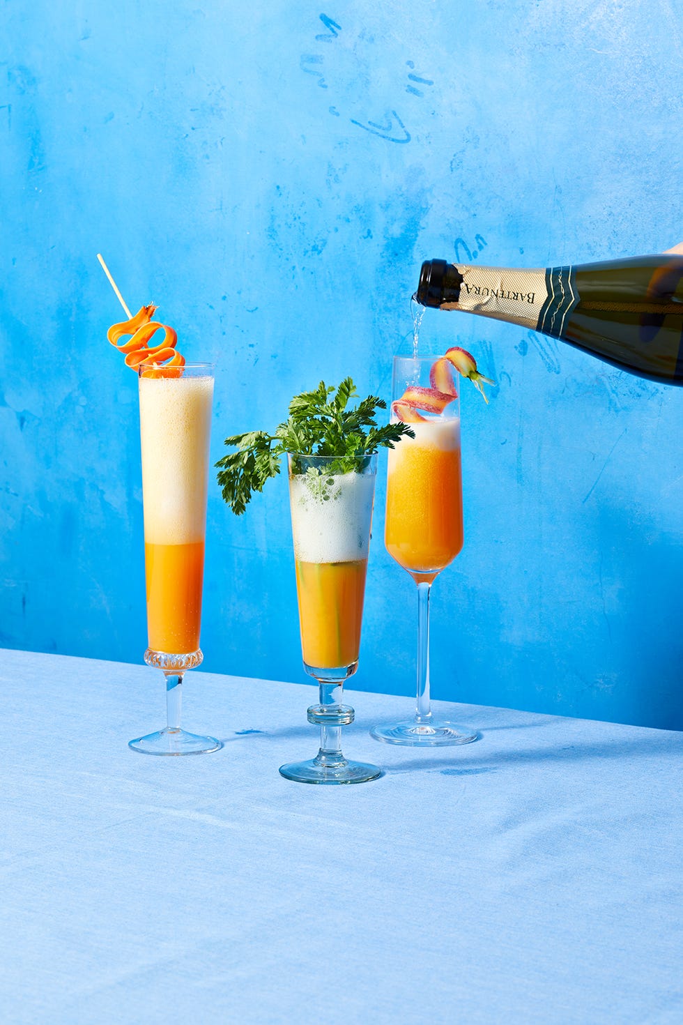 carrot mimosas in three flute glasses