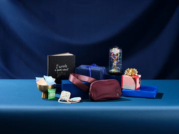 gift items arranged on a blue surface including a book decorative boxes and a storage bag