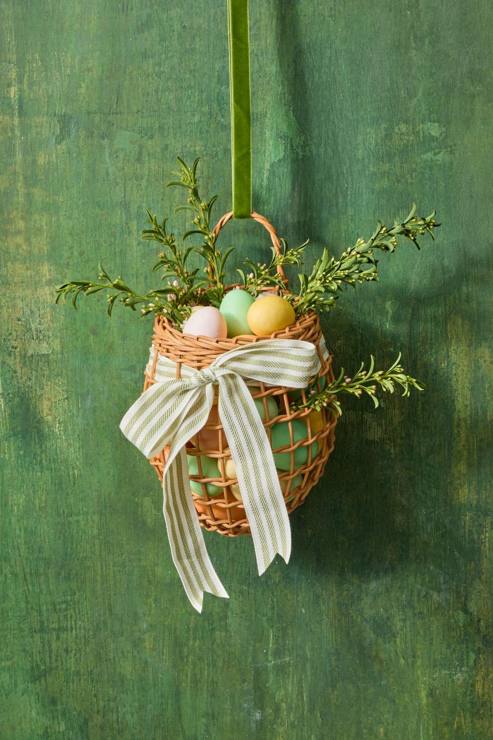 hanging basket containing decorative easter eggs and greenery
