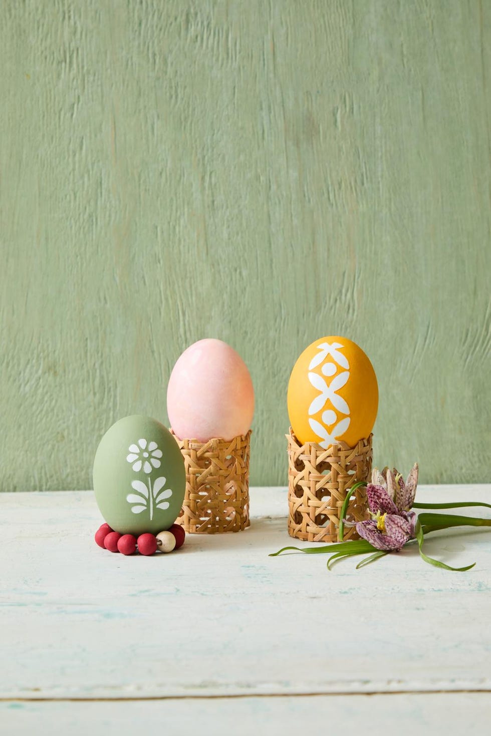 decorated easter eggs displayed in woven holders
