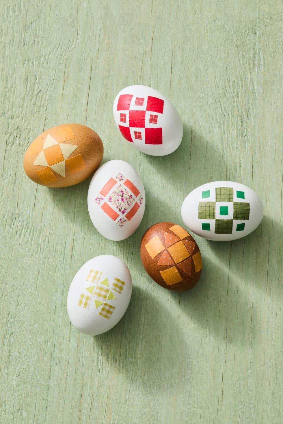 decoratively painted eggs arranged on a green surface