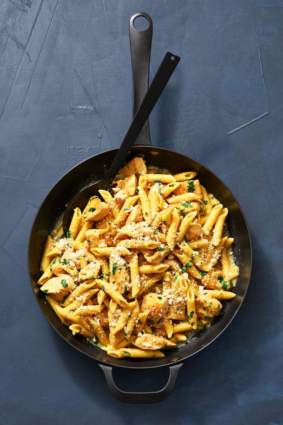 chicken francese pasta in a skillet on blue surface