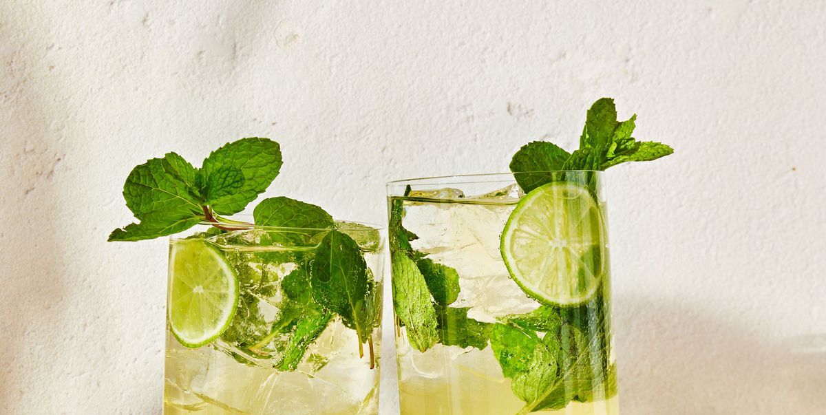 two hugo spritz cocktails with lime and mint clinking