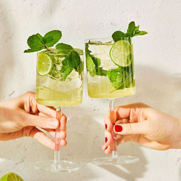 two hugo spritz cocktails with lime and mint clinking