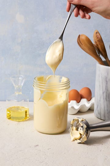 jar of homemade mayonnaise with a spoon pulling out with a dollop