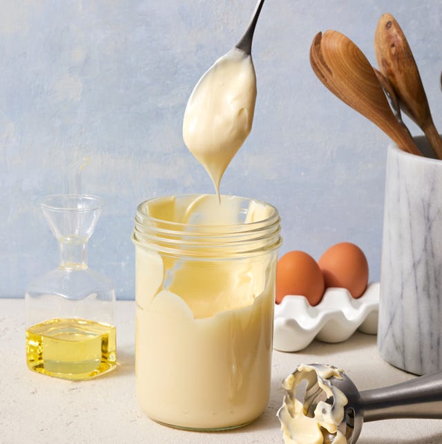 homemade mayonnaise jar of homemade mayonnaise with a spoon pulling out with a dollop