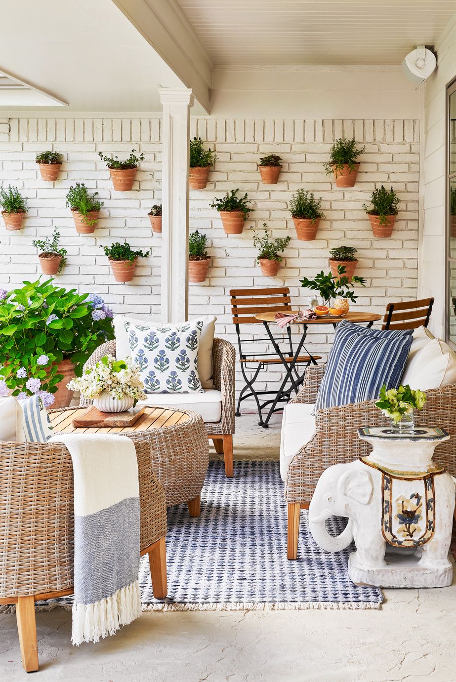 Wall potted plants, woven patio furniture, rattan, wicker mounted on white brick wall