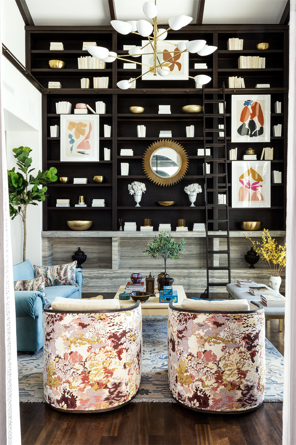 Living room with black bookcase and floral armchair