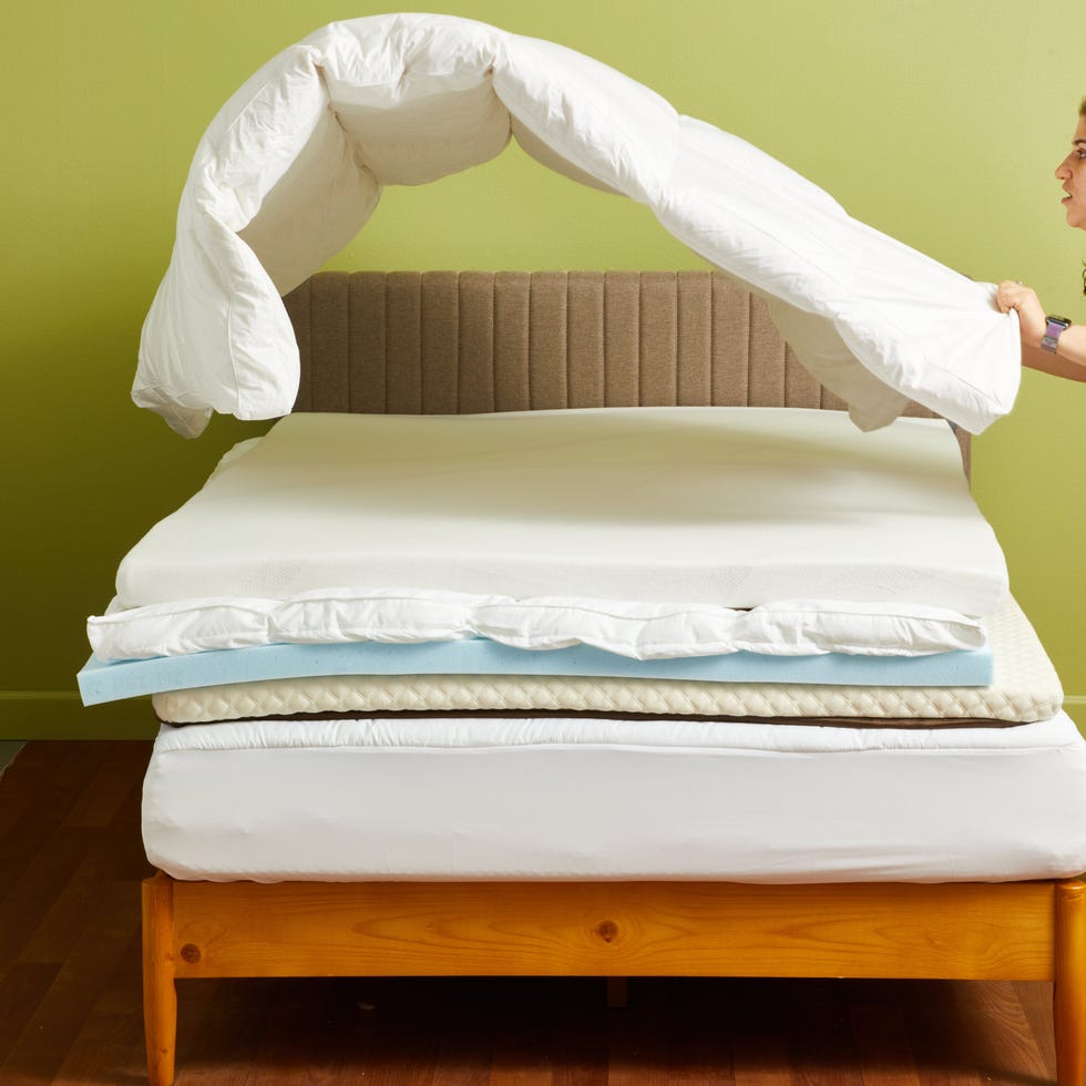 best cooling mattress toppers - how we test a person adjusts a topper on a bed