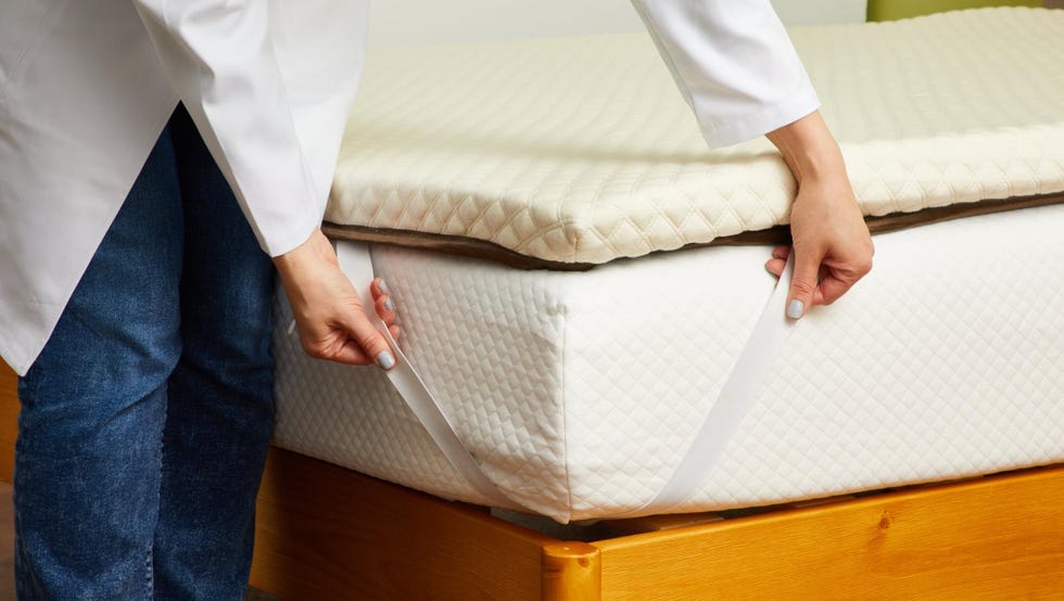 best memory foam mattress toppers a gh analyst putting straps from a mattress topper from nolah onto a mattress