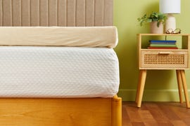 a mattress topper with a beige cover on a white mattress