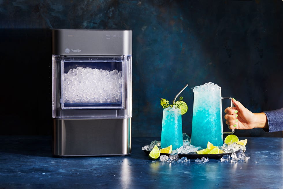 a pitcher of blue mocktails with a lime wedge