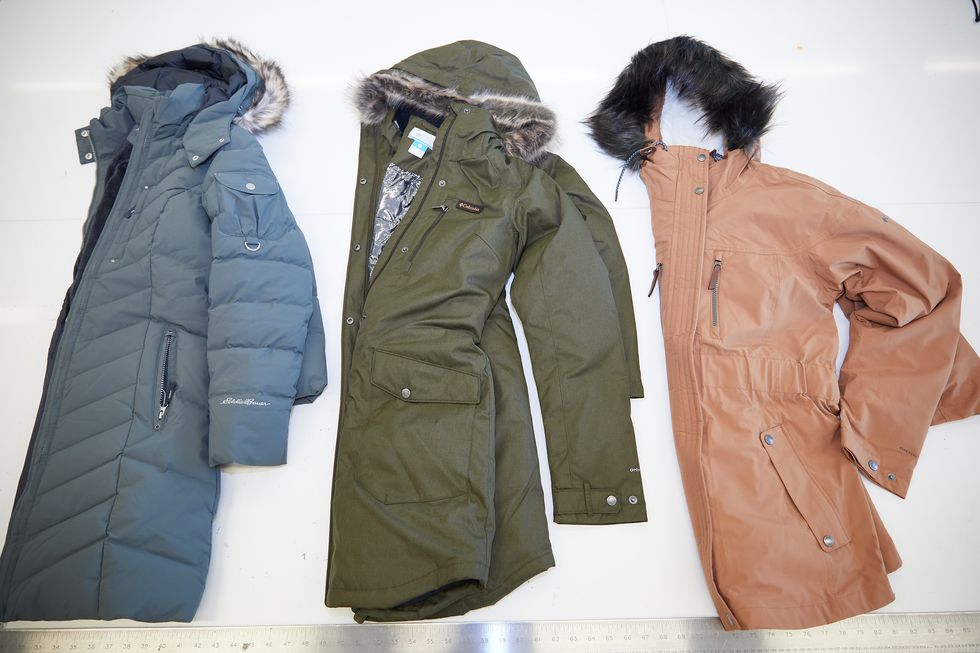 three winter coats laid out on a counter in the good housekeeping institute for testing