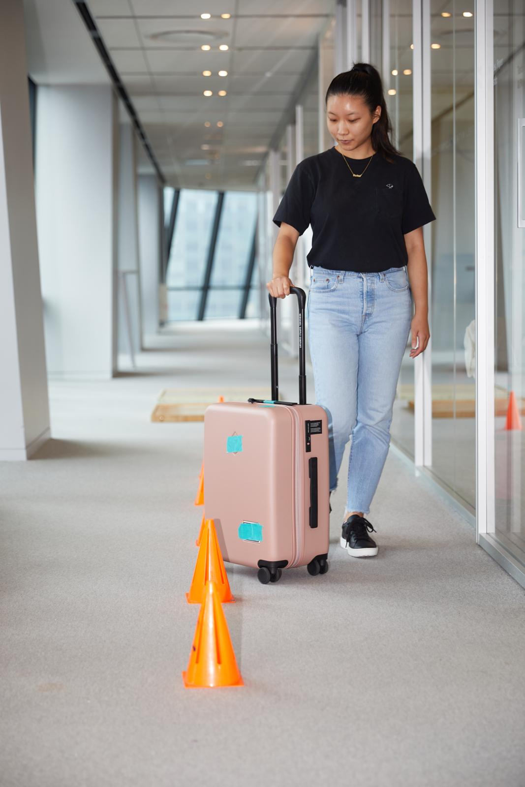 a good housekeeping tester rolling a suitcase through our luggage obstacle course