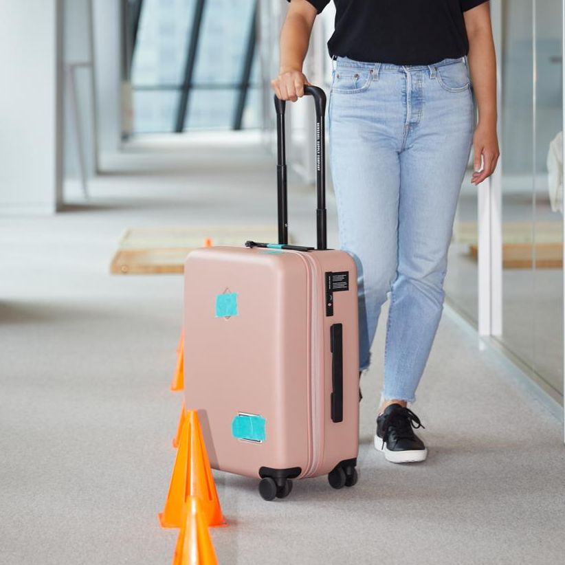 a good housekeeping tester rolling a suitcase through our luggage obstacle course