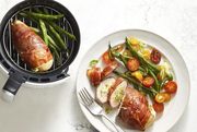 cheese herb air fryer stuffed chicken on white marble table