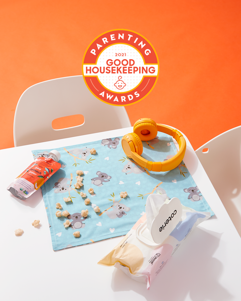 good housekeeping's 2021 parenting awards logo and table with kids' snacks, wipes, and earphones