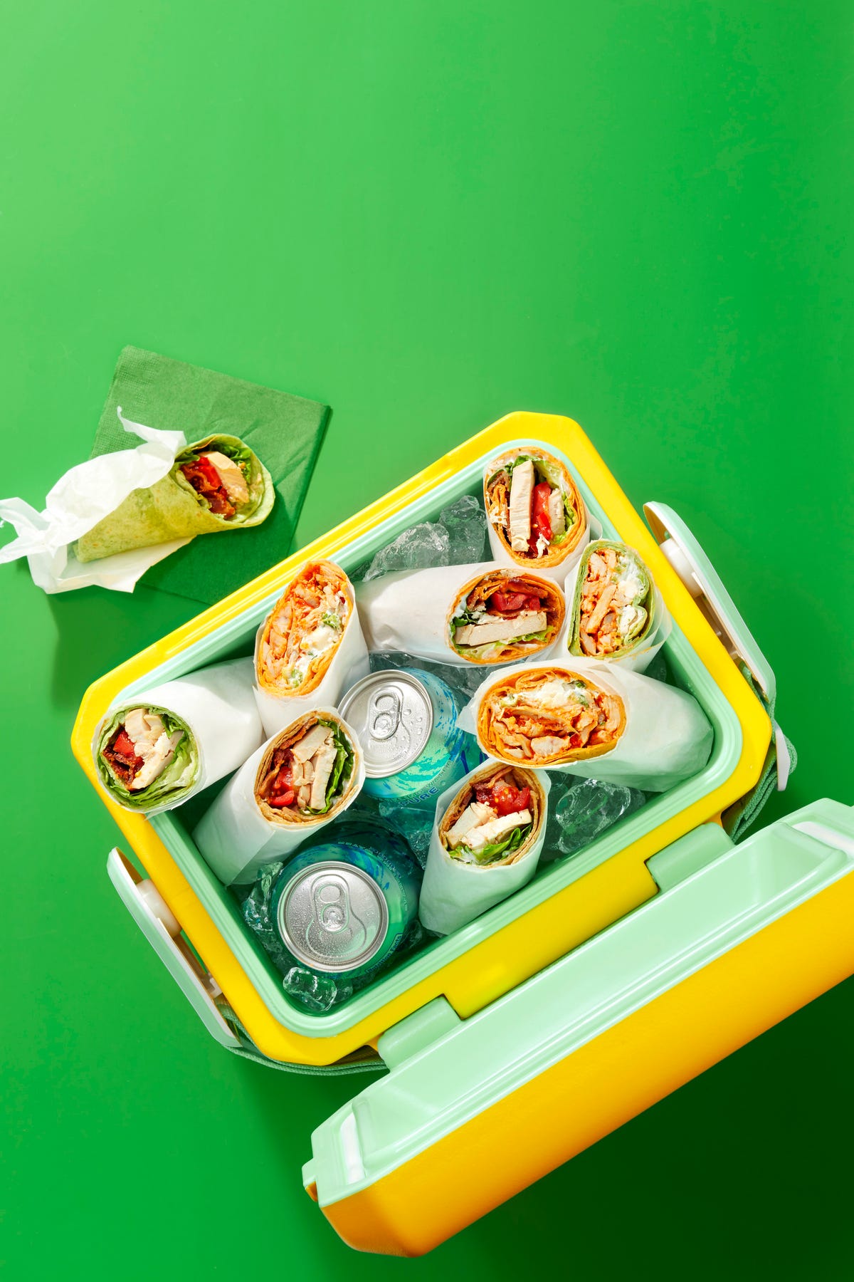 chicken wraps and cans of soda in an ice cooler
