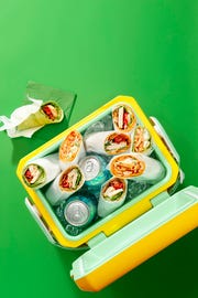 chicken wraps and cans of soda in an ice cooler