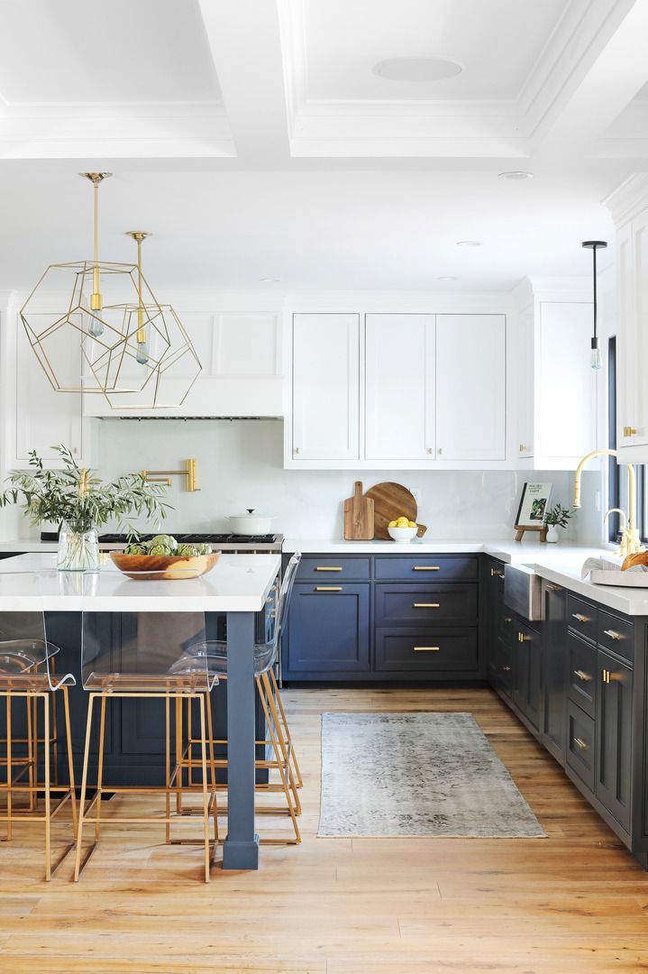 kitchen with dark lower cabinets and bright upper cabinets wood floors, brass fixtures, pendant lamps from arteriors pacific palisades home of interior designer heather lucas
