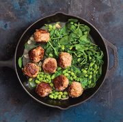 meatballs with spinach and peas in a skillet