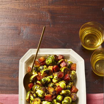 brussels sprouts with heaps of bacon in a white platter