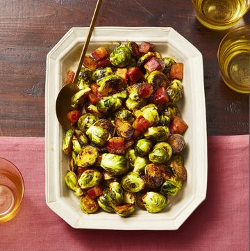 brussels sprouts with heaps of bacon in a white platter