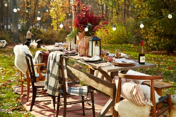 fall decor ideas, outdoor setup with a table, plaid throw blankets and chairs