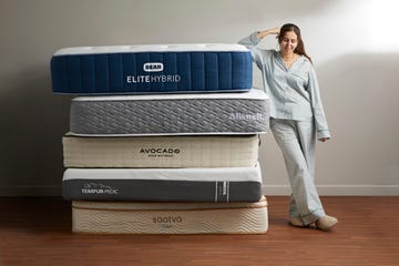 stack of mattresses with a person beside them