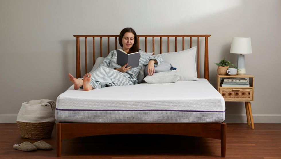 good housekeeping mattress testing a person lounging on a mattress reading a book