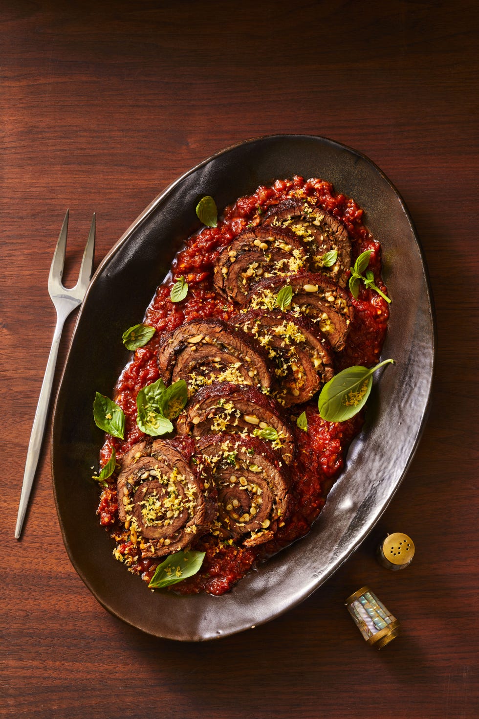 sicilian style braciole over pureed tomatoes, served on a platter