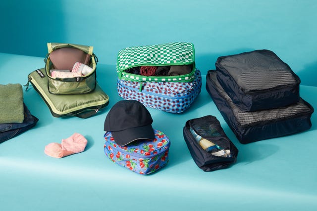 variety of packing cube sets on a blue set, good housekeeping's best packing cubes