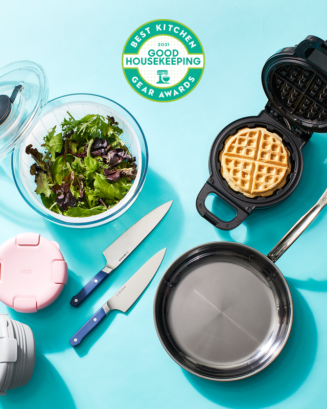 above view shot of kitchen appliances knives, frying pan, salad bowl and waffle maker with good housekeeping kitchen gear awards logo