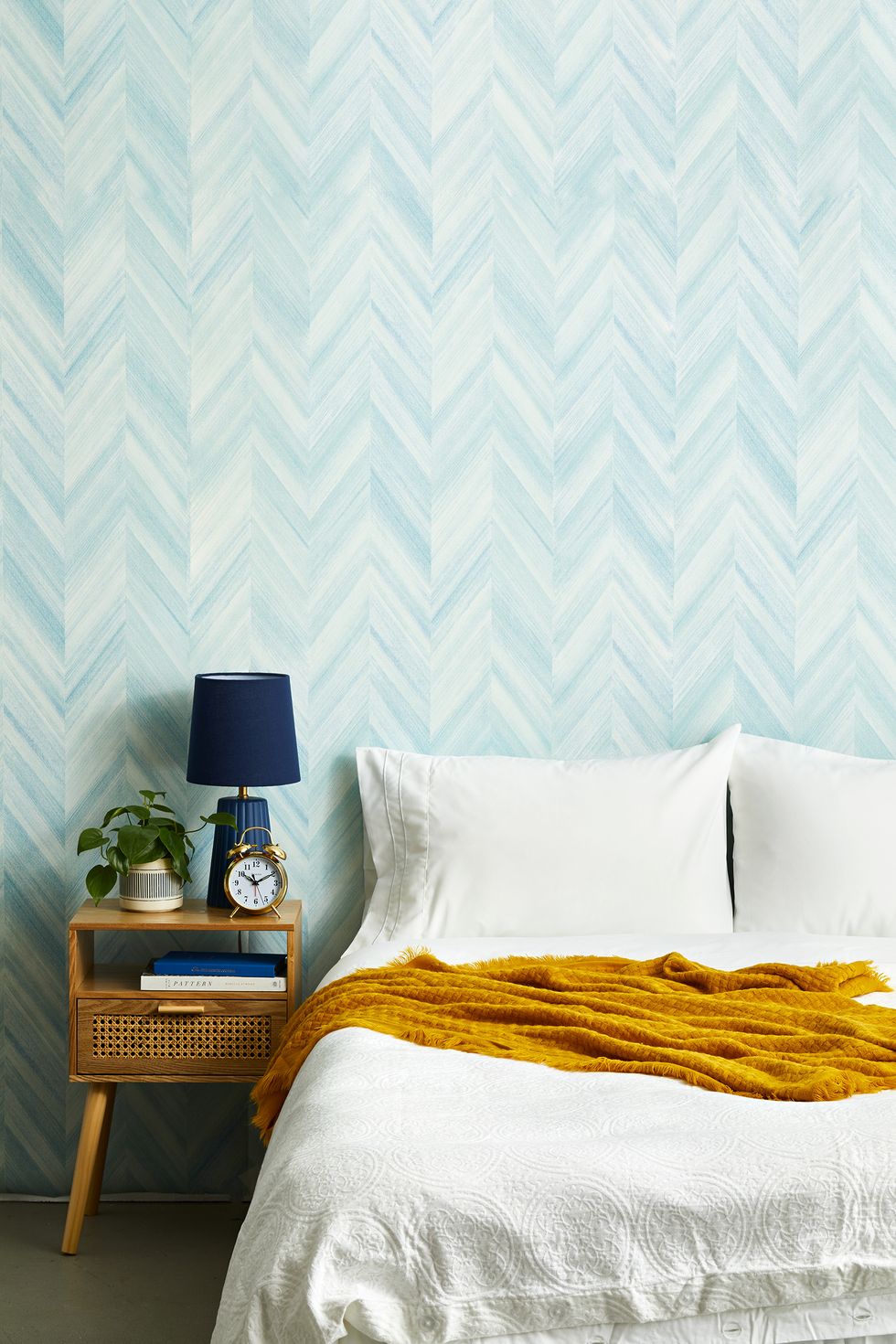 bright bedroom with blue wallpaper, white linens, yellow blanket, alarm clock sleep, calm