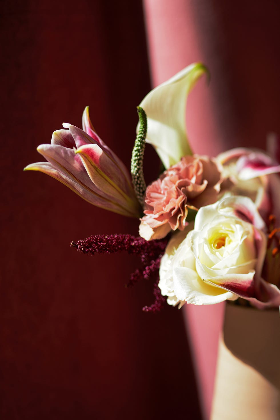 bouquet of lillies and roses with a strobe of light highlighting the petals