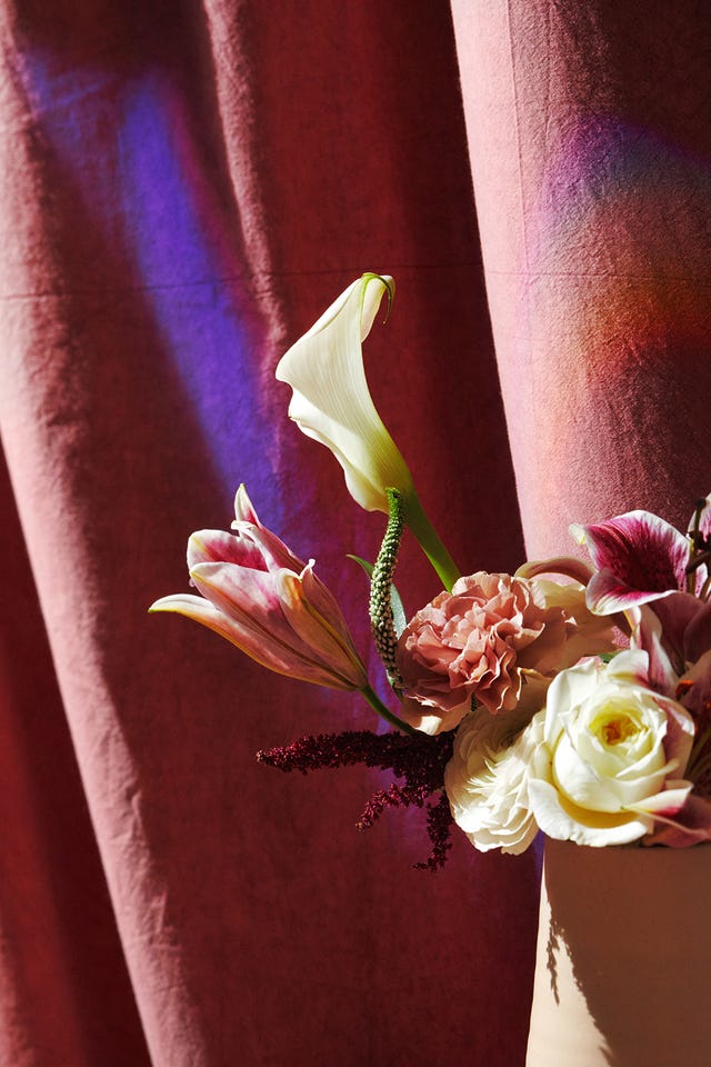 bouquet of lillies and roses with a strobe of light highlighting the petals