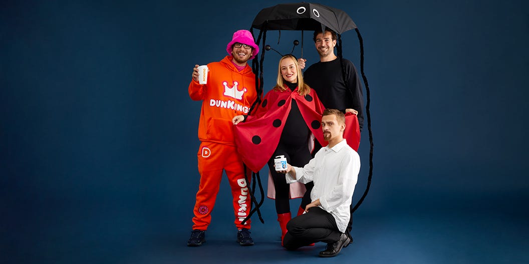 four individuals are standing together in a playful arrangement