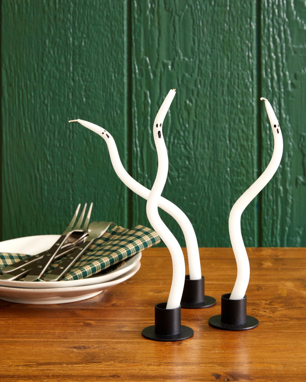 thin white taper candles bent to be wavy and look like ghosts thin white taper candles bent to be wavy and look like ghosts