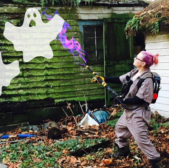 woman in ghostbusters costume fighting white ghosts