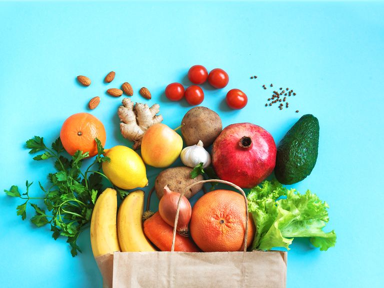 healthy food background healthy vegan vegetarian food in paper bag vegetables and fruits on blue, copy space, banner shopping food supermarket and clean vegan eating concept