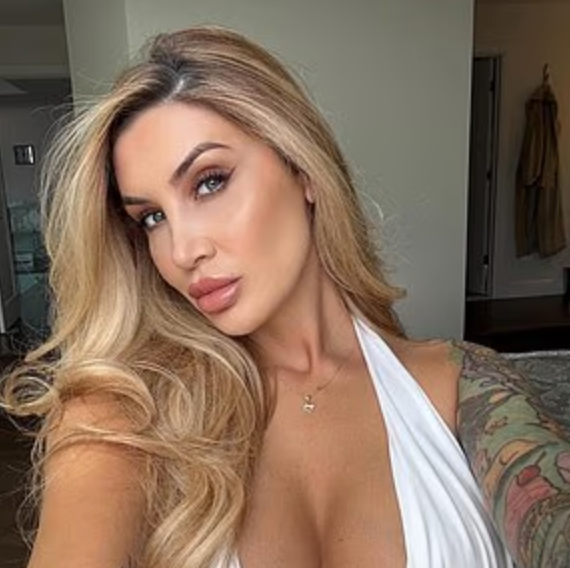 a woman with long blonde hair wearing a white dress with a tattoo on her arm