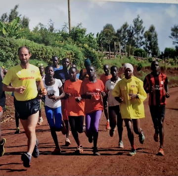 group of runners training on a dirt road surrounded by greenery