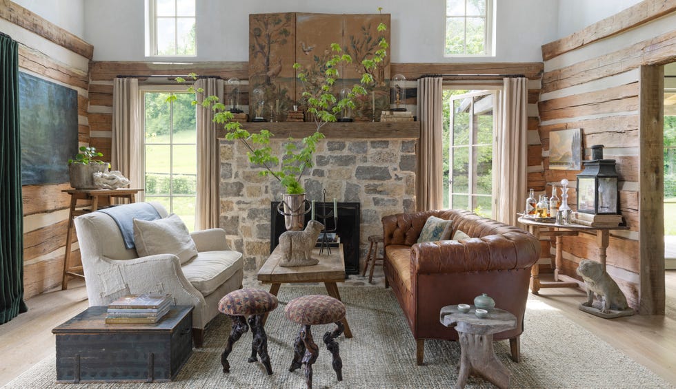 living room with stone hearth, log walls, and two couches facing each other