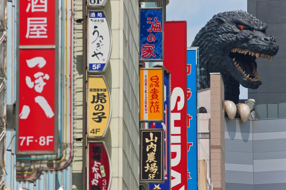 giant godzilla statue atop toho cinema in the shinjuku kabukicho district of tokyo, japan