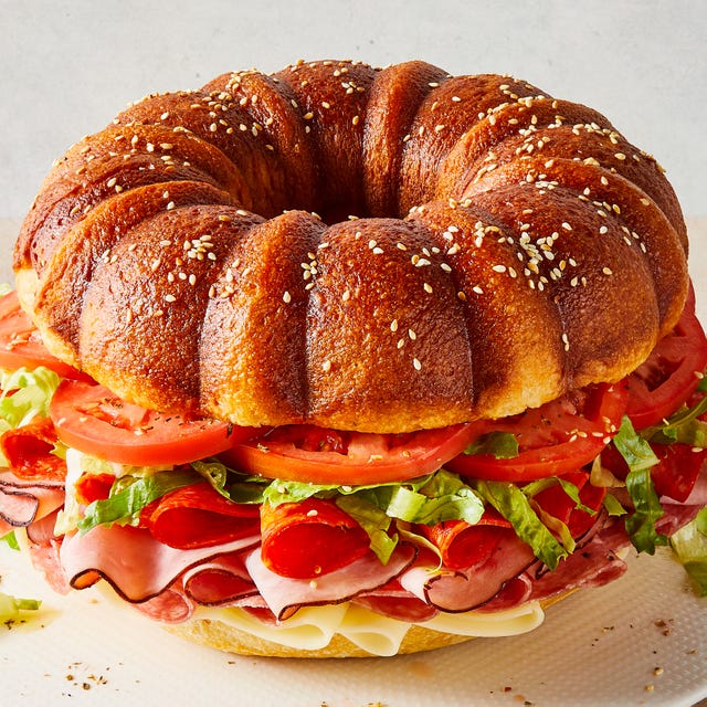 bundt cake bread filled with sliced salami, ham, provolone, tomatoes, lettuce, and pepperoni