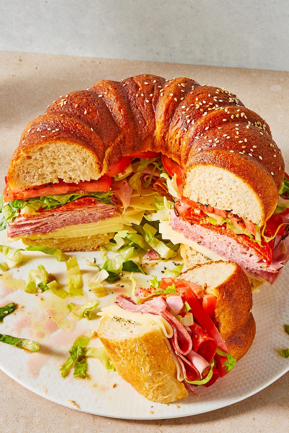 Huge Party Sub Bundt cake bread stuffed with sliced salami, ham, provolone, tomato, lettuce and pepperoni