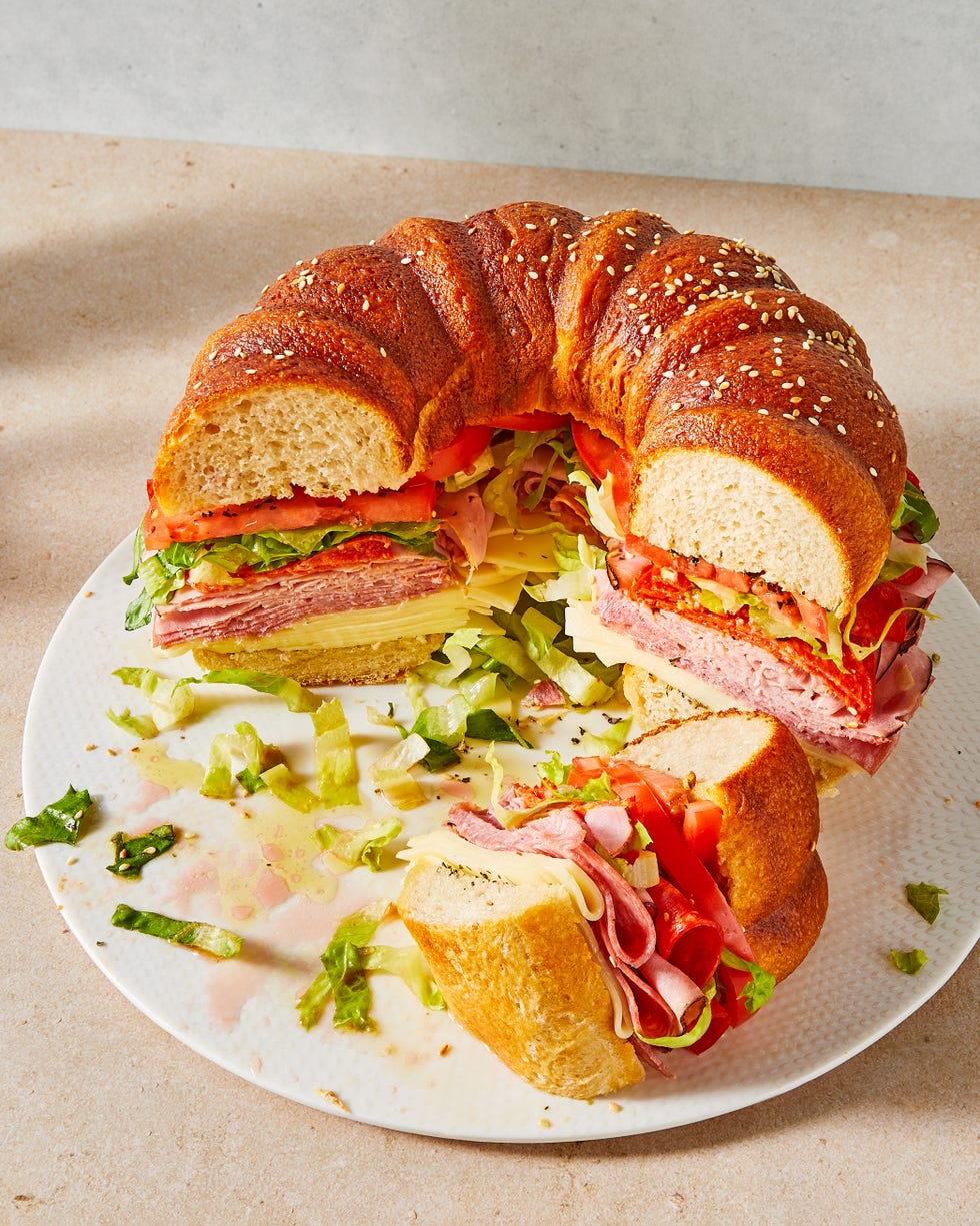 bundt cake bread filled with sliced salami, ham, provolone, tomatoes, lettuce, and pepperoni