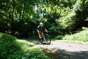 a man riding a bicycle on a trail in the woods