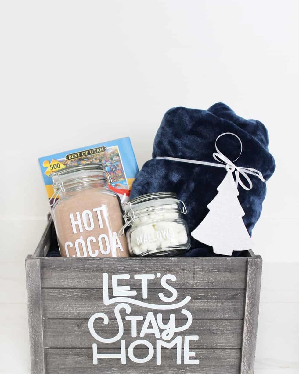 cozy gift basket made in a gray wooden box that says lets stay home